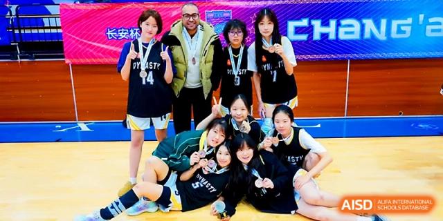 A girls' sports team posing with their coach after a successful match at Maple Leaf International School - Xi_an.