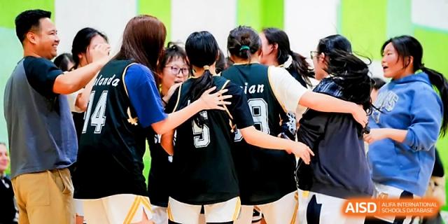 A group of basketball players in a huddle during a timeout at Maple Leaf International School - Xi_an.