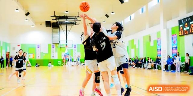 Students competing for the ball during an indoor basketball game at Maple Leaf International School - Xi_an.