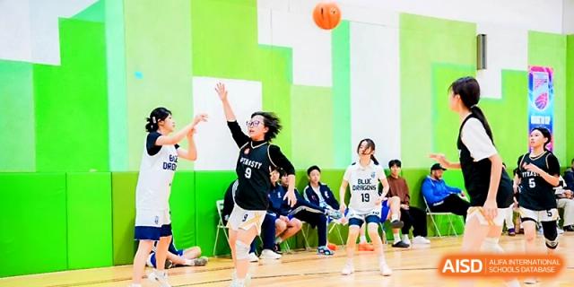A female student attempting a layup during a basketball game at Maple Leaf International School - Xi_an.
