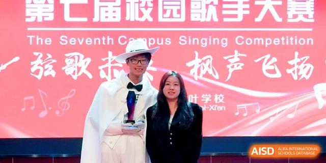 Two students posing with a trophy at a campus singing competition at Maple Leaf International School - Xi_an.