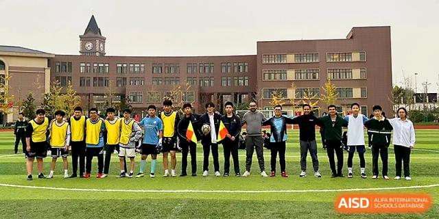 A group of students and faculty posing together on an outdoor field at Maple Leaf International School - Xi_an.