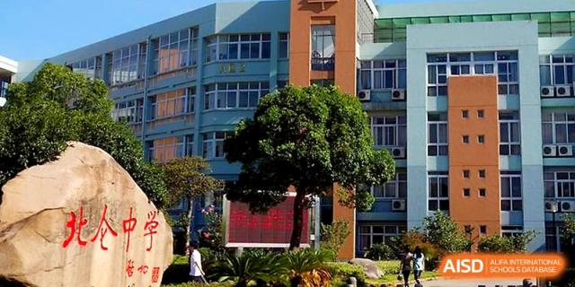 The multi-story school building features blue glass windows and a prominent digital display screen at Ningbo Beilun High School.