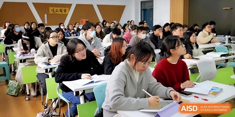 A student takes detailed notes during a specialized academic presentation in a modern lecture hall at Ningbo Beilun High School.