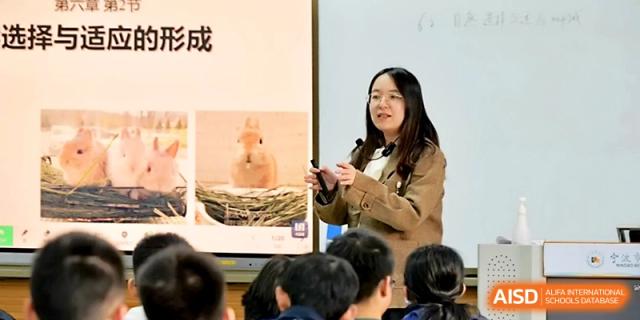 A female teacher gives a presentation featuring a slide about animal habitats to her students at Ningbo Beilun High School.