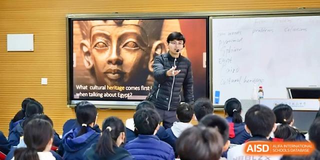 A teacher delivers a history lecture featuring a large image of an Egyptian pharaoh on the screen at Ningbo Beilun High School.