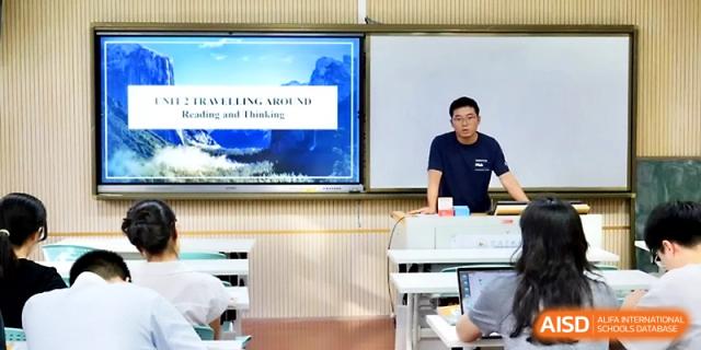 A male teacher leads a geography lesson titled "Traveling Around" using a digital map on the screen at Ningbo Beilun High School.