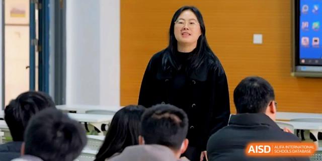 A female educator leads an interactive classroom discussion with focused students at Ningbo Beilun High School.