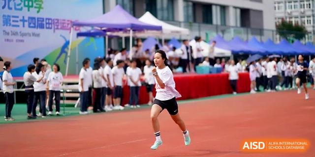 A female student sprints with determination down the red track during a competitive race at Ningbo Beilun High School.