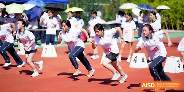 Two students compete in a fast-paced sprint as spectators cheer from the sidelines at Ningbo Beilun High School.