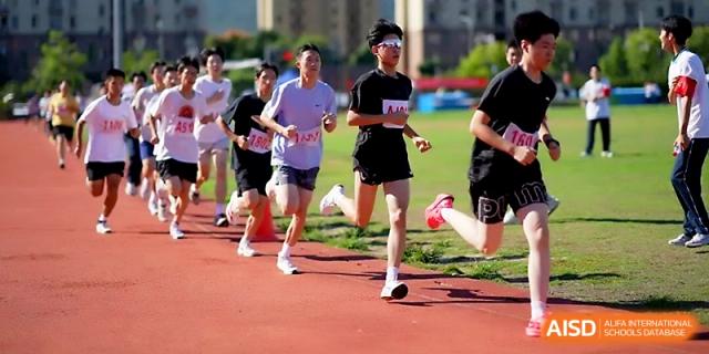 A group of students in purple jerseys competes in a long-distance running event on the track at Ningbo Beilun High School.