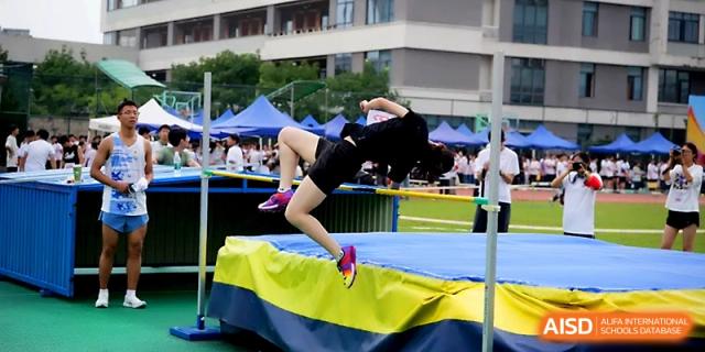 An athlete performs a high jump, successfully arching over the bar during a school sports meet at Ningbo Beilun High School.