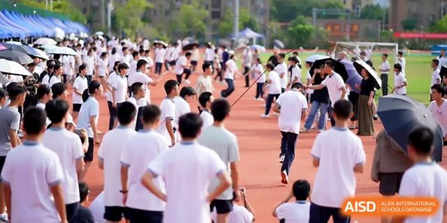 A large crowd of students gathers on the field to participate in the sports day opening at Ningbo Beilun High School.