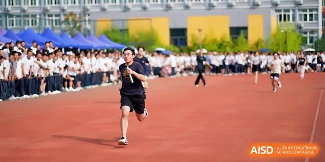 A male student athlete finishes a sprint with a strong burst of energy on the track at Ningbo Beilun High School.