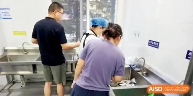 Staff members oversee the food preparation process to maintain high hygiene levels at Ningbo Beilun High School.