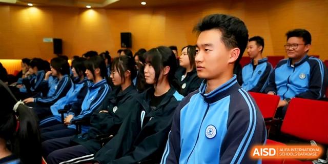 A close-up of students in blue and navy tracksuits sitting attentively during a large school assembly or lecture at The High School Affiliated to Xi_an Jiaotong University.
