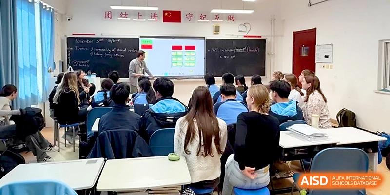 An educator uses an interactive whiteboard to teach a class of attentive local and international students at The High School Affiliated to Xi_an Jiaotong University.