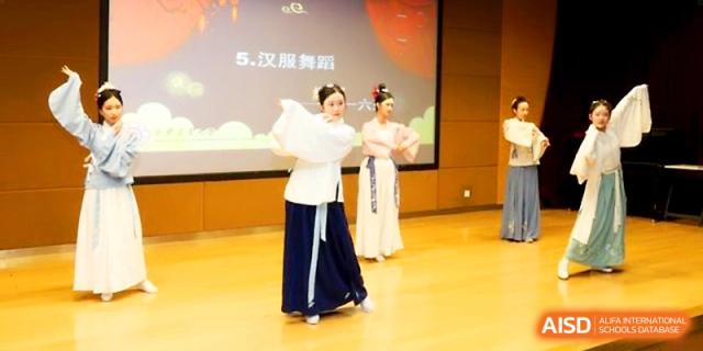 Students in traditional Chinese costumes perform a graceful dance on stage during a cultural festival at The High School Affiliated to Xi_an Jiaotong University.