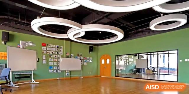 An empty, modern classroom or studio space features unique circular ceiling lights at Wahaha International School.