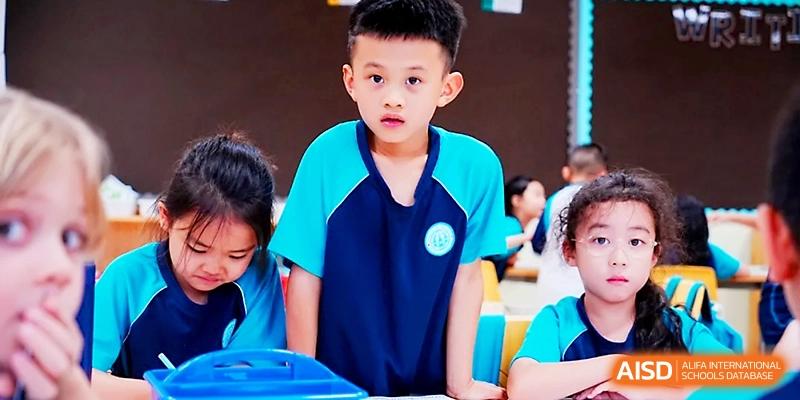 A young student in a blue polo shirt looks on during a classroom activity at Wahaha International School.