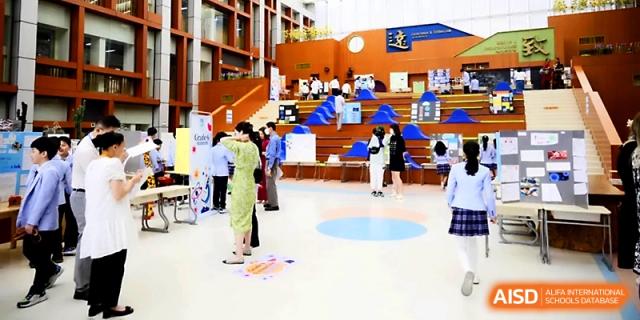 An expansive indoor atrium or common area is filled with students and displays at Wahaha International School.
