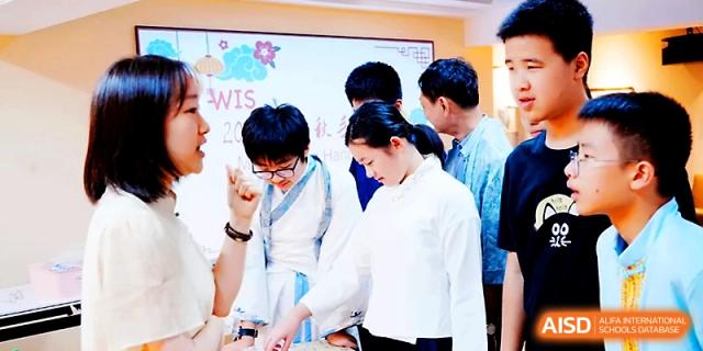 Students in traditional-style white clothing participate in a school event or ceremony at Wahaha International School.