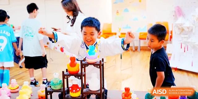 A joyful student plays with a colorful stacking toy during an indoor activity at Wahaha International School.