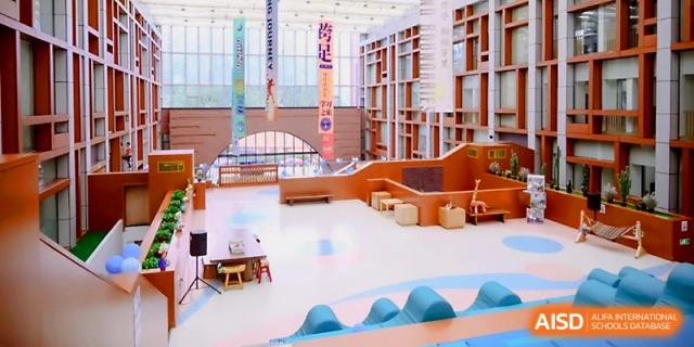A high-angle view shows the spacious, multi-level library or learning center at Wahaha International School.