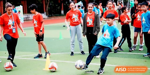Students practice soccer skills and ball control on the outdoor athletic field at Wahaha International School.