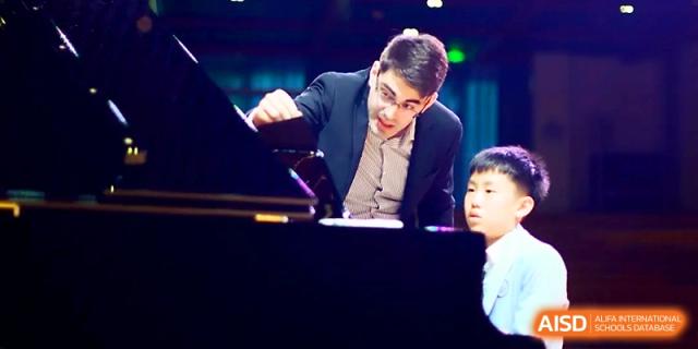 A pianist performs a focused musical piece during a formal school concert or event at Wahaha International School.