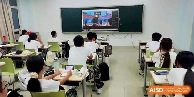 Students are seated in a modern classroom, actively taking notes while a presentation is displayed on the front screen at WeiFang No.1 Middle School.