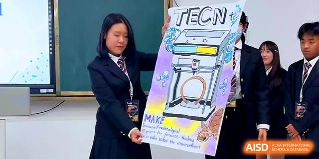 A female student in a dark blazer presents a large hand-drawn poster titled "TECN" featuring a scientific device at WeiFang No.1 Middle School.