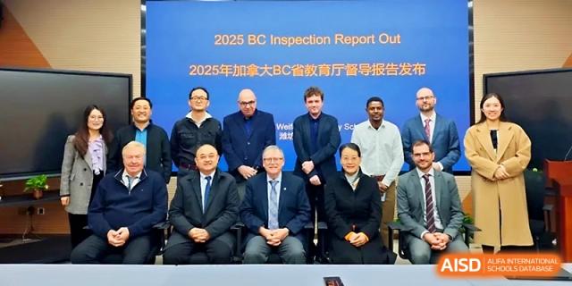 A group of faculty and officials pose for a formal group photo in front of a blue backdrop for a report at WeiFang No.1 Middle School.