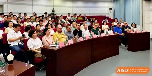 An audience of parents and educators attends a formal presentation in a lecture hall to discuss student progress at Wuhan No.2 High School.
