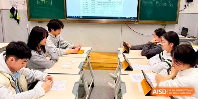 Students sit at modern desks using tablets for a collaborative digital learning assignment in a classroom at Wuhan No.2 High School.