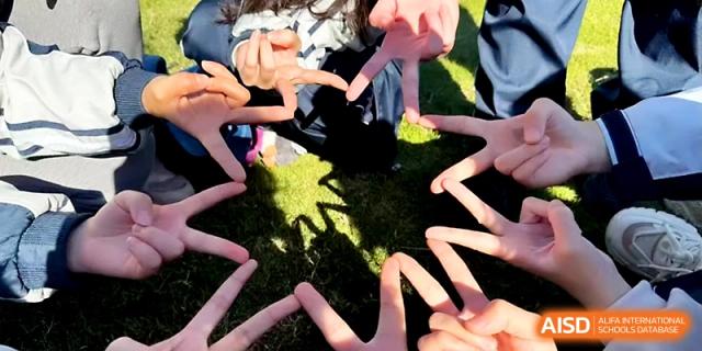 Students join their hands together to form a star shape, symbolizing unity at Wuhan No.2 High School.