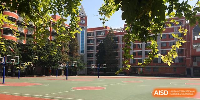 A wide shot of the outdoor basketball courts and the main school building at Wuhan No.2 High School.