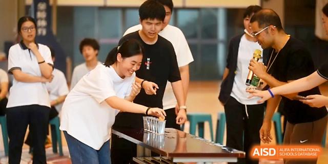 A boy and girl work together to complete a skill-based challenge during sports day at Wuhan No.2 High School.