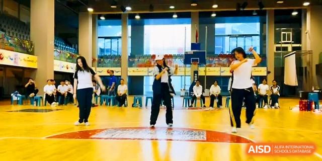 A student performs a dance routine in the center of the indoor gymnasium at Wuhan No.2 High School.