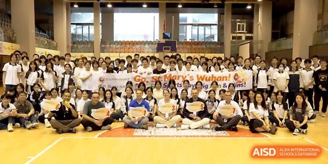 A large group of students and teachers pose for a commemorative photo in the gym at Wuhan No.2 High School.