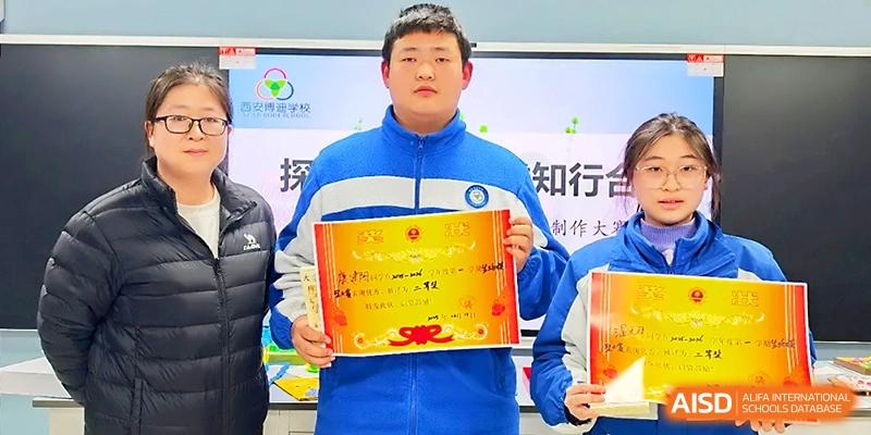 A young man in a blue jacket holds up a prestigious merit certificate during a school recognition ceremony at Xi_an Bodi School.