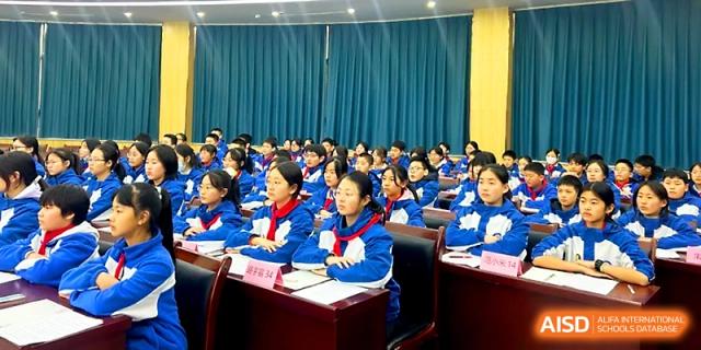 Rows of students in blue uniforms sit attentively during a formal school assembly or lecture at Xi_an Bodi School.
