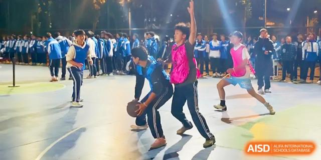 Students play an active game of basketball on an outdoor court during an evening sports event at Xi_an Bodi School.