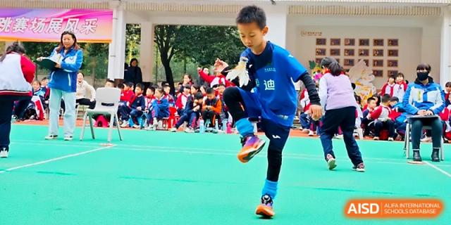 A boy in a blue shirt performs a kicking exercise during an outdoor sports and culture event at Xi_an Bodi School.