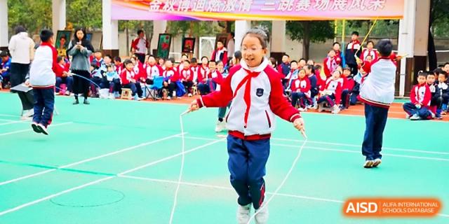 A young girl smiles while jumping rope during a sports competition on the outdoor school grounds at Xi_an Bodi School.