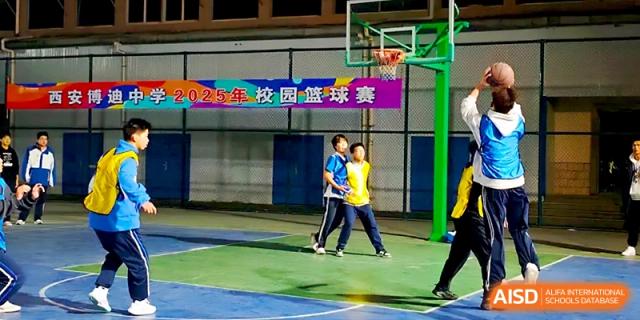 Students walk across a basketball court with a festive banner visible in the background at Xi_an Bodi School.