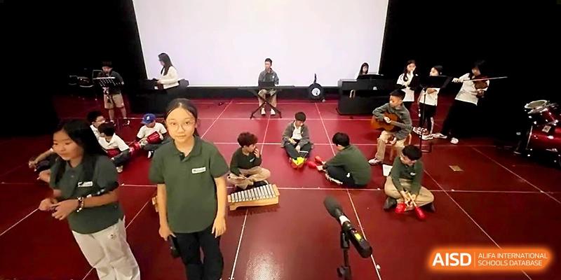 Students practice various musical instruments, including the xylophone and guitar, on a performance stage at Xi_an Hanova International School.