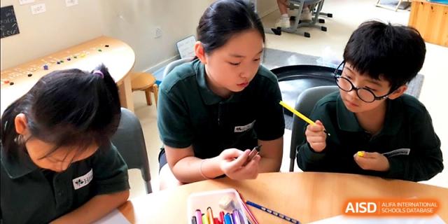 A young student focuses on a creative craft project during a classroom activity at Xi_an Hanova International School.