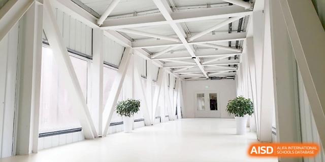 A bright, modern indoor walkway with large windows and a minimalist architectural design at Xi_an Hanova International School.