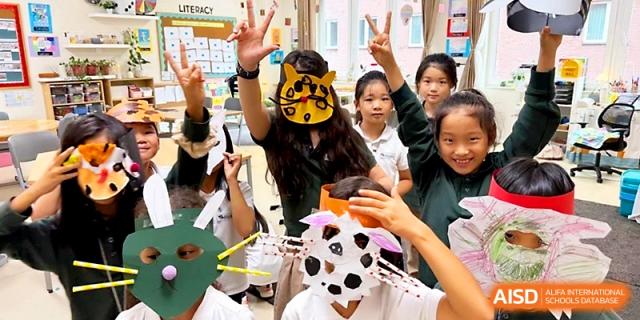 Happy students wear animal masks and colorful costumes for a school performance or party at Xi_an Hanova International School.